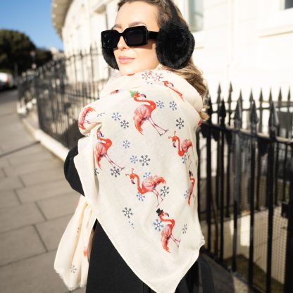 Blonde lady standing outside white buildings in chelsea, wearing an all back outfit, taupe jumper and a hand printed festive flamingos design scarf with black sunglasses on