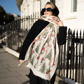 Blonde lady standing outside white buildings in chelsea, wearing an all back outfit, taupe jumper and a hand printed gonks design scarf with black sunglasses on